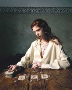 a woman sitting at a table with cards in front of her