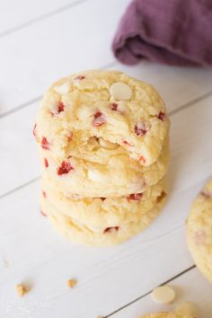 three cookies stacked on top of each other with white chocolate chips scattered around them and one cookie in the middle