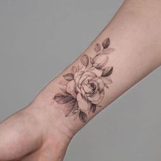 a woman's arm with a rose tattoo on it and the wrist is shown