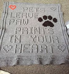 a crocheted afghan with a paw print on it