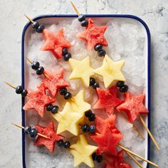 star shaped fruit skewers on ice with berries and blueberries in the middle