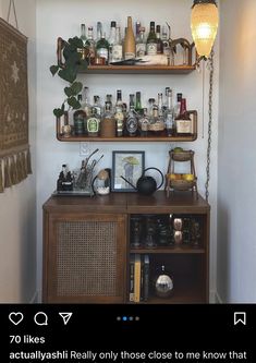 a shelf filled with lots of bottles next to a wall mounted clock and light fixture