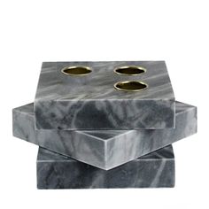 three marble candlesticks stacked on top of each other with gold rings in the middle