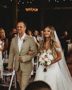 a bride and groom walking down the aisle