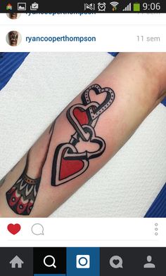 a woman's arm with a heart and two hearts tattoo on the left forearm