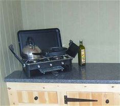 a stove top oven sitting on top of a counter next to a bottle of wine