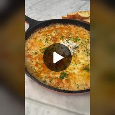 a skillet filled with food sitting on top of a counter next to toasted bread