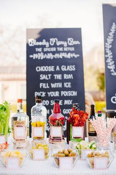 a table topped with lots of food next to bottles of alcohol and candy bar signs