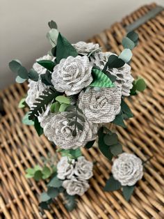 some white flowers and green leaves on a wicker basket