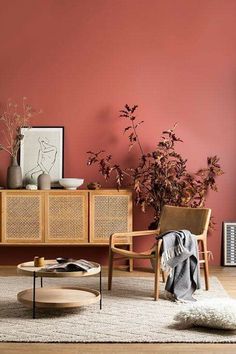 a living room with pink walls and wicker furniture in the corner, including a coffee table