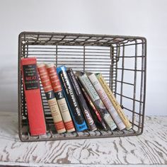 there is a metal basket with books in it