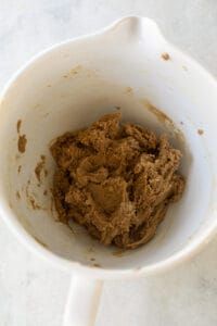 a white cup filled with brown stuff on top of a table