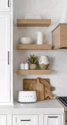 the kitchen is clean and ready to be used for cooking or baking, with white cabinets and wooden shelves