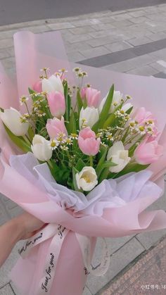 a person holding a bouquet of flowers on the street