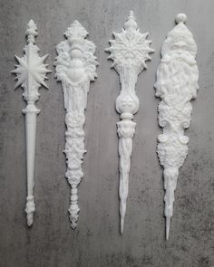 four white decorative objects are lined up on the wall