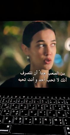 a woman making a funny face in front of a laptop computer with arabic writing on the screen