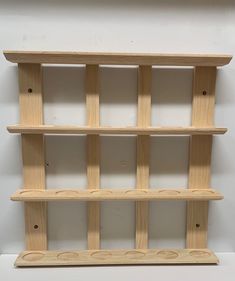 three wooden shelves with holes in the middle and two on each shelf, all lined up