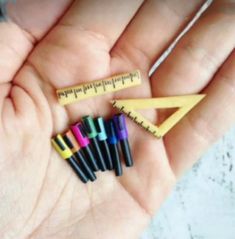 several crayons are in the palm of someone's hand with a ruler