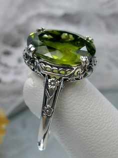 "Natural Green Peridot Sterling Silver Ring Edward Design#70z (smaller version) Custom Made Inspired by Edwardian jewelry of the early 1900s, I now offer this lovely Antique reproduction ring in sterling silver. This gorgeous ring is set with a stunning 4ct Natural Green Peridot gemstone. This genuine Peridot has good color and clarity (VS). The oval cut Peridot is 12mm (9/16th of an inch) Long by 10mm Wide (3/8th\"). The ring sits 6mm off the finger. The inside of the band s marked 925 for ster Stock Design, White Opal Ring, Edwardian Jewelry, Gorgeous Ring, Sparkly Things, Peridot Ring, Peridot Gemstone, Sterling Silver Filigree, Jewelry Lookbook