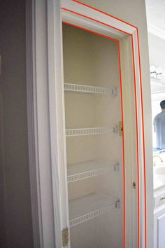 a man standing in front of a bathroom mirror with red lines on the wall next to it