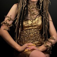 a woman with dreadlocks and gold dress