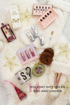 the contents of a holiday gift set are laid out on a white fur covered blanket