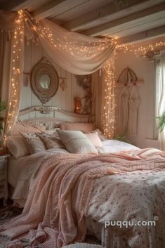 a white bed with pink comforter and lights on the headboard in a bedroom