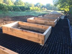 several wooden boxes are lined up on the ground in order to be used as planters