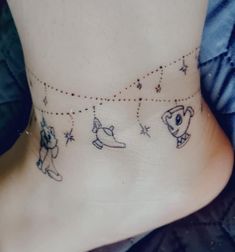 a small ankle tattoo with animals and stars on it