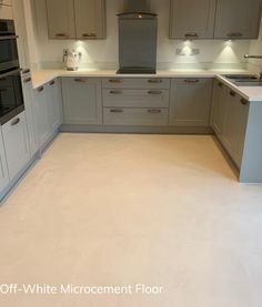 an empty kitchen with white and grey cabinets