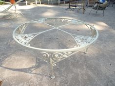 a white metal table sitting on top of a cement ground