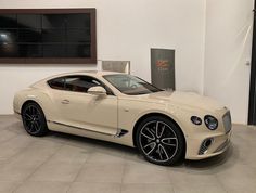 a white car is parked in a showroom