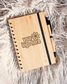 a wooden notebook with the words you logo here on it sitting on a furry surface