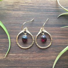 Mini Gold and Garnet Hoops.  14k gold fill hammered hoops, polished to a high shine. 14k gold fill wrapped natural, faceted Garnet. Deep red with hints of magenta. Finished with 14k gold filled hooks.  Measurements: 1" long and 3/4" wide. Made in and shipped from Tupper Lake, New York. Gold And Red Earrings, Garnet Drop Earrings With Ear Wire, Gold Garnet Teardrop Earrings, Hammered 14k Gold-filled Hoop Earrings, 14k Gold-filled Wire Wrapped Dangle Earrings, Gold Garnet Faceted Earrings, Mini Gold, Garnet Crystal, Gold And Red