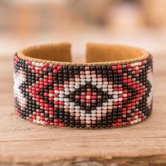 a close up of a bracelet on a wooden surface