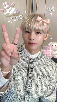 a person with blonde hair making the peace sign