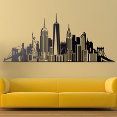 a living room with a couch and a wall decal that has a city skyline on it