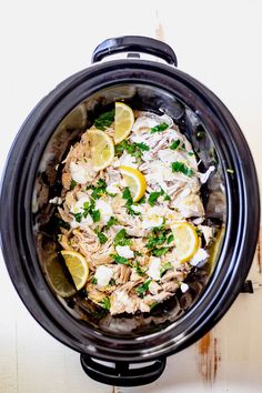 a crock pot filled with chicken and lemons