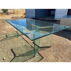 a glass table sitting on top of dirt covered ground