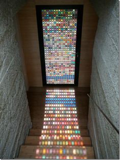 the stairs are covered with many colored glass tiles and there is a large window in the center