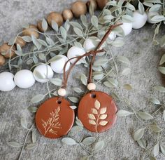 two brown tags with leaves on them are sitting next to some eggs and greenery