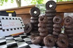 chocolate donuts stacked on top of each other in front of a checkered table cloth