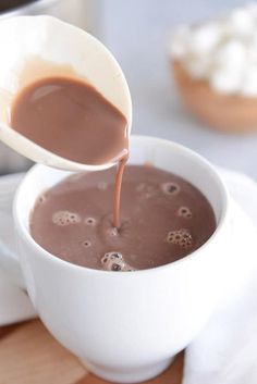 a spoon pouring chocolate into a white bowl