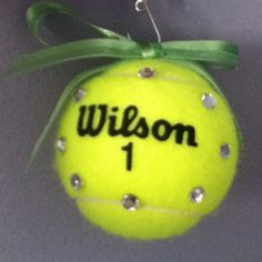 a tennis ball ornament with the name wilson on it