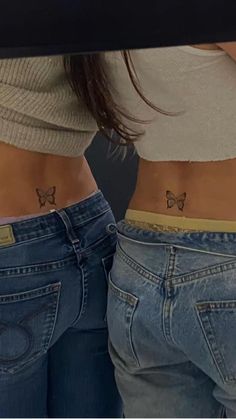 two women with small tattoos on their stomachs, one has a butterfly and the other has