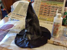 a witches hat sitting on top of a table next to a newspaper and glue bottle