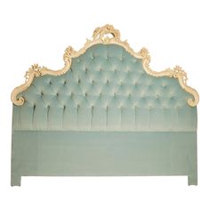 a blue bed with gold trimmings and an ornate headboard on the side