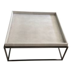 a square metal tray sitting on top of a white table with a black frame around it