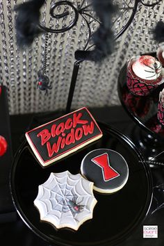 black widow cookies and other halloween treats on a table