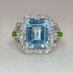 an aqua and white topaz ring with green accents